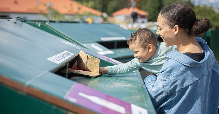 En kvinna och ett barn återvinner pappersförpackningar på en återvinningscentral.