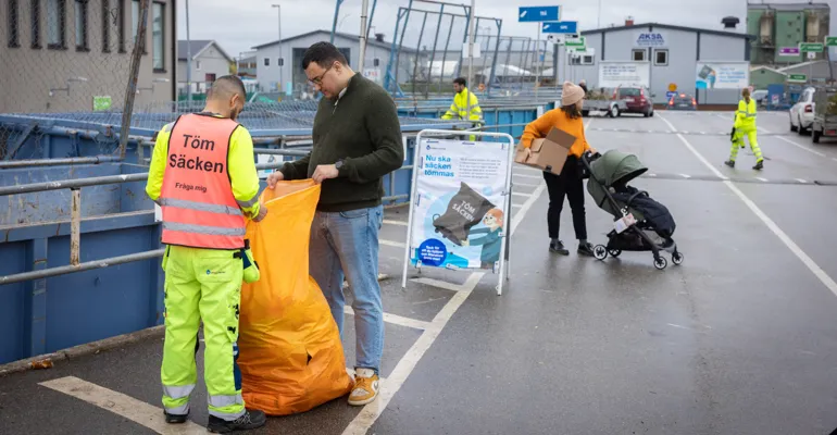 Man som får hjälp av personalen på en återvinningscentral