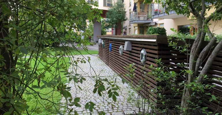 Lummig innergård med fastighetsnära insamling i kärlskåp